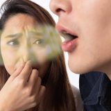 lady holding nose due to bad breath or halitosis